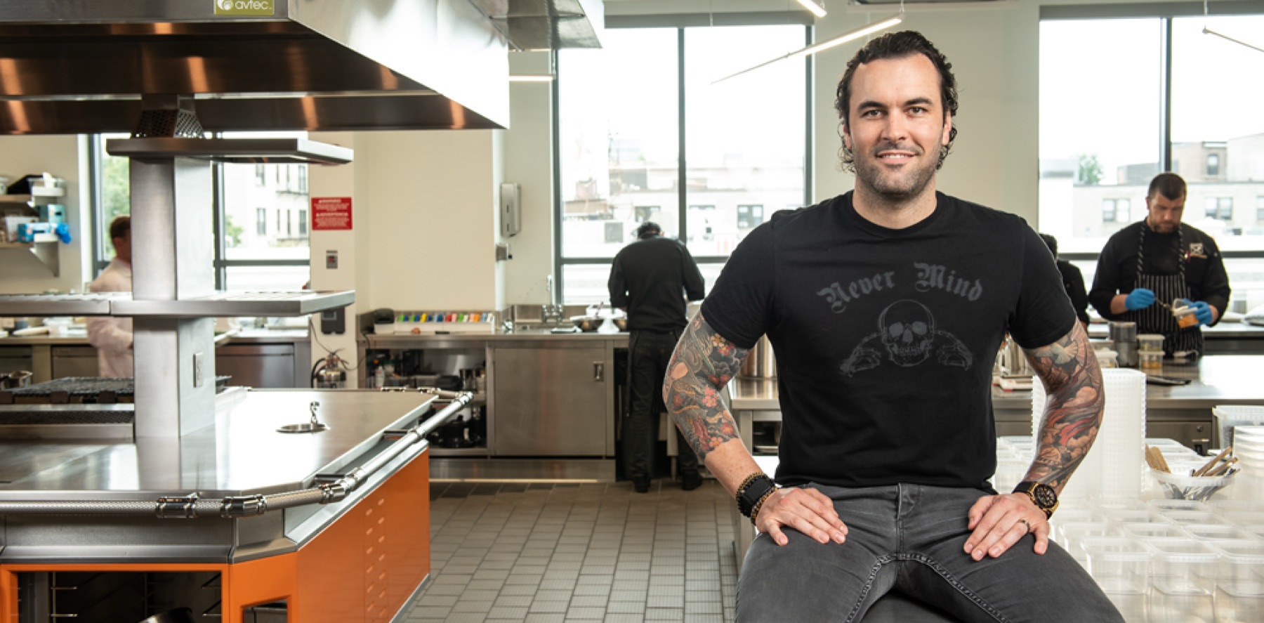 Adam Melonas seated in a CHEW kitchen.